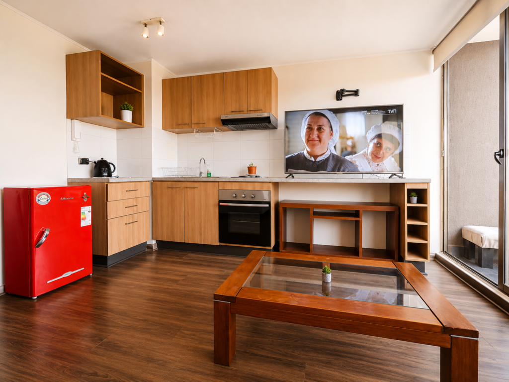 Cocina del Departamento San Miguel con refrigerador rojo y mesa de centro